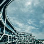A striking modern building with a unique hexagonal pattern under a cloudy sky, offering urban architectural beauty.